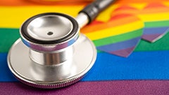 lgbtq pride rainbow heart shaped stickers next to a stethoscope