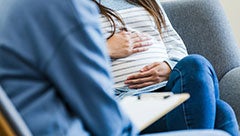 Rural/urban differences in rates and predictors of intimate partner violence and abuse screening among pregnant and postpartum United States residents. Stock image shows a pregnant woman sitting on a sofa across from a counselor holding a clipboard. Faces are cropped out